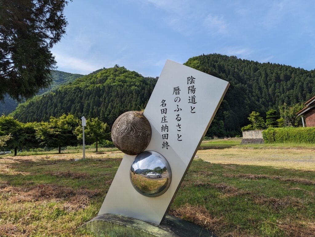 「陰陽道と暦のふるさと　名田庄納田終」と記された看板。国道162号沿い、駐車場の目印。